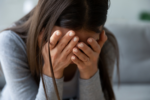 Woman covering her face in grief after losing a loved one