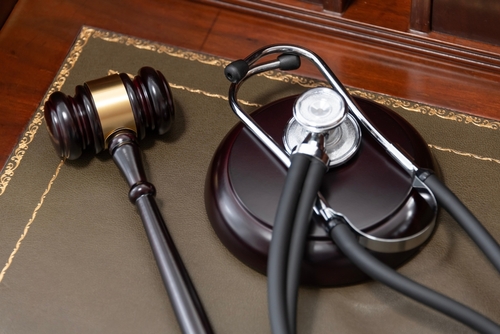 Gavel and stethoscope placed together on a judge’s desk symbolizing medical malpractice law.