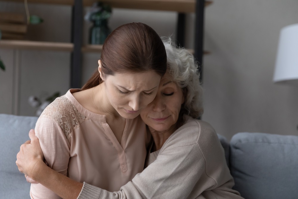 Two women embracing and comforting each other, representing a grieving family pursuing a Maryland wrongful death claim