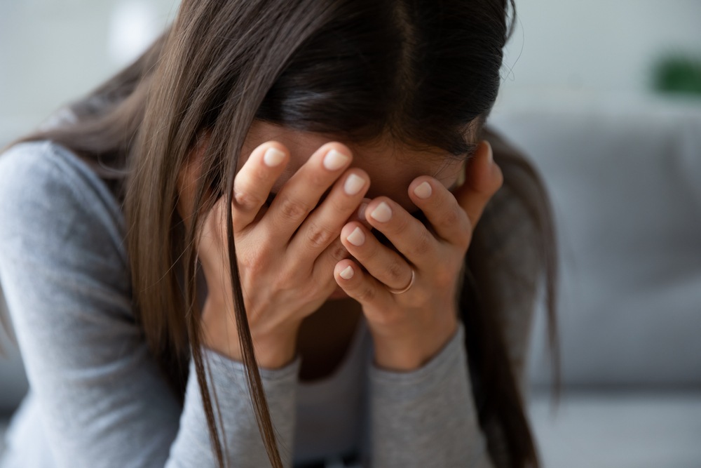 Woman covering her face in grief, representing solatium damages for mental anguish in a Maryland wrongful death case